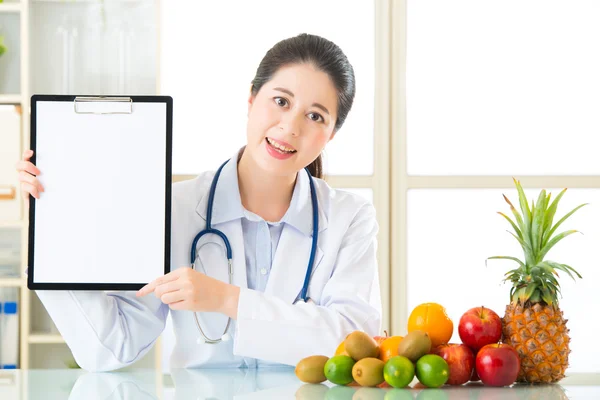 Dokter voedingsdeskundige met vruchten en bedrijf leeg Klembord — Stockfoto