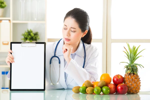 Dokter voedingsdeskundige met vruchten en bedrijf leeg Klembord — Stockfoto