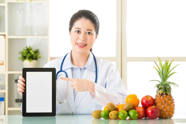 Doktor beslenme meyveleri ve holding dijital tablet — Stok fotoğraf