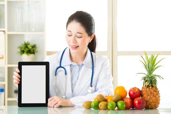 Doktor beslenme meyveleri ve holding boş dijital tablet — Stok fotoğraf