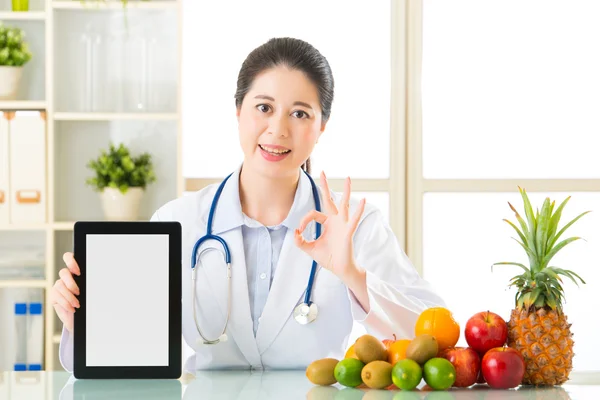 Doktor beslenme dijital tablet ve ok sı tutan meyve ile — Stok fotoğraf
