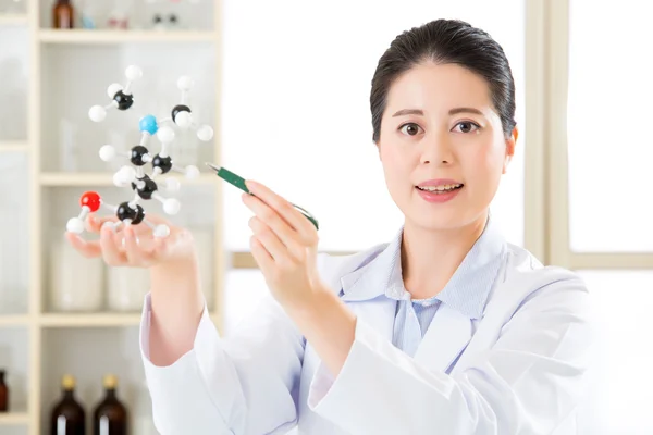 Asiatisk kvinnlig kemist lärare punkt på molekylär modell förklara SC — Stockfoto