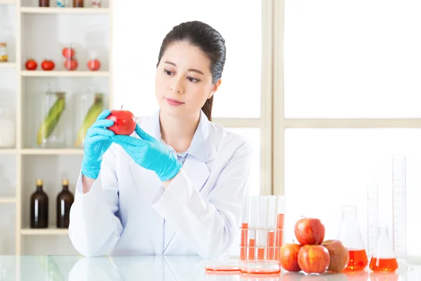 Asian female scientist looking apple for genetic modification re — Stock Photo, Image