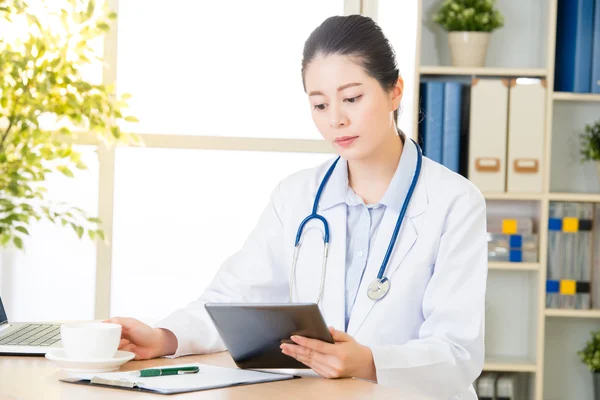 Dokter drinken koffie met behulp van digitale tablet onderzoek patiënt van medi — Stockfoto