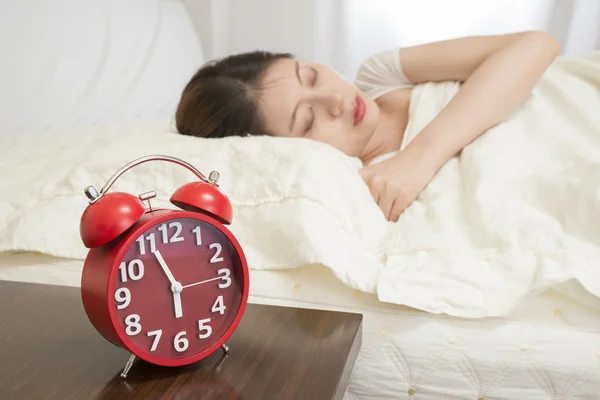 Woman sleeping in bed beside alarm clock — Stock Photo, Image