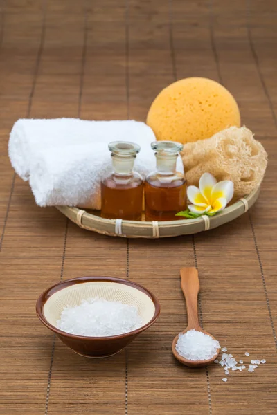 Spa bath, salt bowl spoon, towel sponge essential oil and flower — Stock Photo, Image