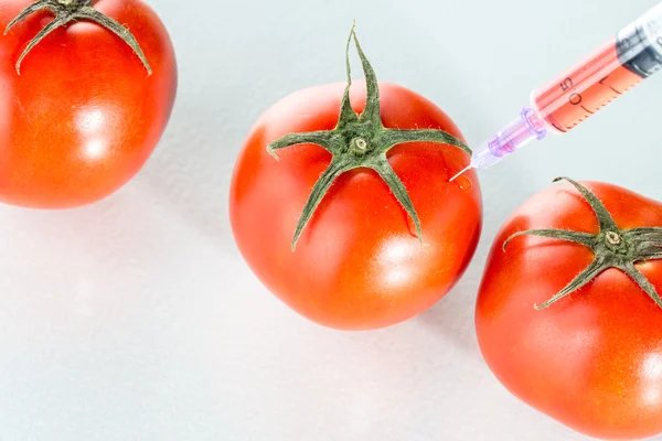 Modificação genética copos de laboratório de tomate vermelho em branco — Fotografia de Stock