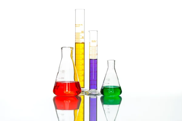 Tudományos laboratóriumi üvegeszközök, fényvisszaverő fehér asztal — Stock Fotó