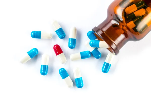 Blauwe capsules en rode capsules met fles, gezondheidszorg en medi — Stockfoto