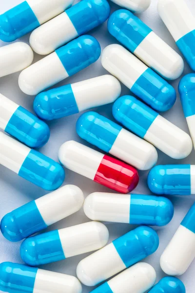 Cápsulas azuis e cápsulas vermelhas, cura de medicamentos de perto — Fotografia de Stock