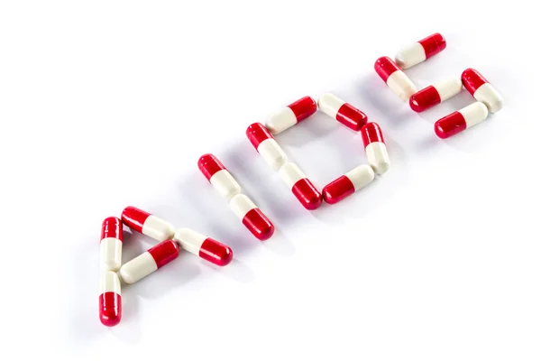 Red with white capsule in AIDS WORD, HIV — Stock Photo, Image