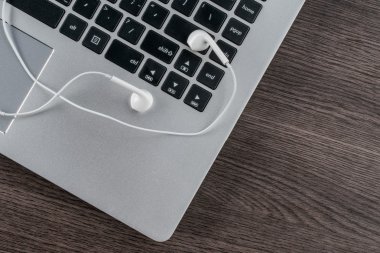ahşap masa üstünde laptop ile kulaklık