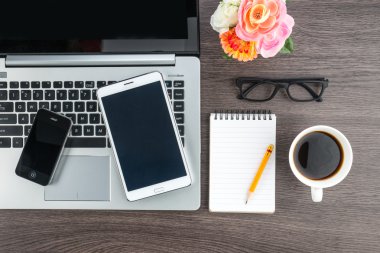 Dizüstü bilgisayar cep telefonu ve masanın üstünde defter ile Tablet 