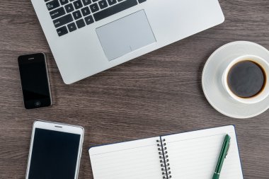 Dizüstü bilgisayar cep telefonu ve masanın üstünde defter ile Tablet 