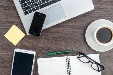 Dizüstü bilgisayar cep telefonu ve masanın üstünde defter ile Tablet 