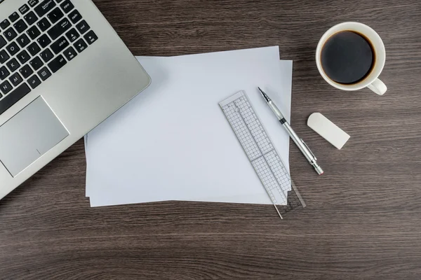 Laptop, papier, pen liniaal en de gum met kop koffie — Stockfoto