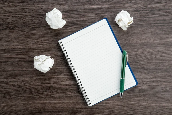 Papel de amassar e caneta com caderno na mesa — Fotografia de Stock