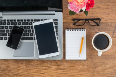 Dizüstü bilgisayar cep telefonu ve masanın üstünde defter ile Tablet 