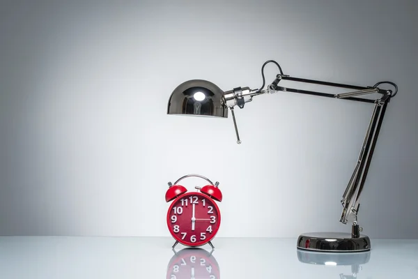 Acender despertador vermelho com lâmpada de mesa — Fotografia de Stock