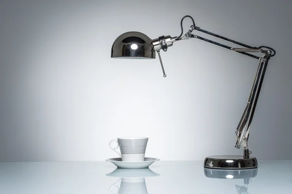 Verlichting van witte mok koffie beker met bureaulamp — Stockfoto