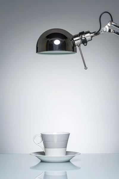Verlichting van witte mok koffie beker met bureaulamp — Stockfoto