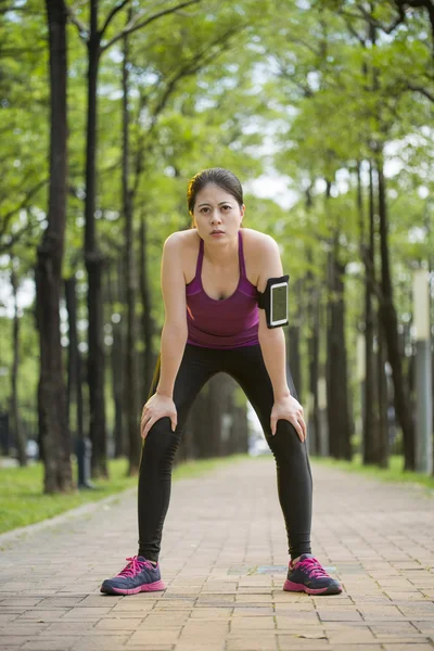 Asian young woman tired because jogging , cell phone — Stock Photo, Image