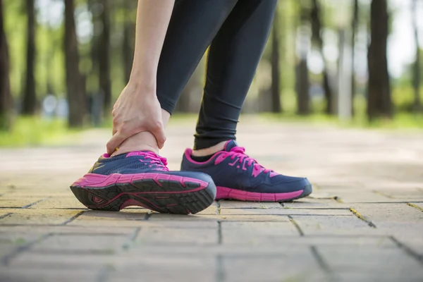 Mujer corredor hold torcido tobillo dolor, pierna humana — Foto de Stock