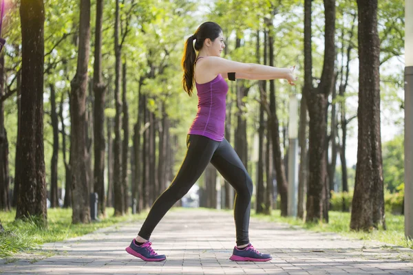 Desportivo jovem asiático mulher alongamento depois de correr na floresta — Fotografia de Stock