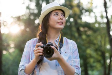 Dijital kamera fotoğraf çekimi ile gülümseyen güzel Asyalı kız,