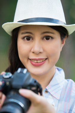 Dijital kamera fotoğraf çekimi ile gülümseyen güzel Asyalı kız,