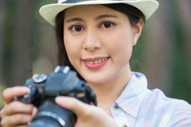 Dijital kamera fotoğraf çekimi ile gülümseyen güzel Asyalı kız,