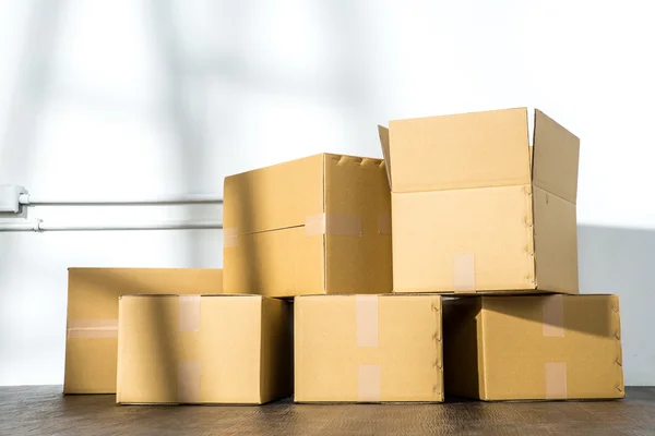 Montón de cajas de cartón sobre fondo blanco con sombra de escalera —  Fotos de Stock