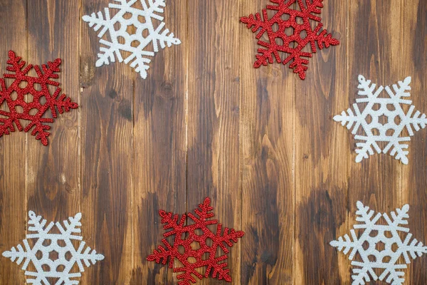 Διακόσμηση λευκό και κόκκινο γυαλιστερό νιφάδες χιονιού σε ξύλο — Φωτογραφία Αρχείου