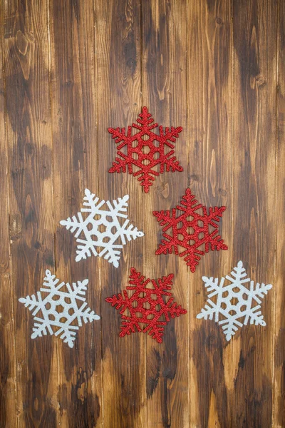 Διακόσμηση λευκό και κόκκινο γυαλιστερό νιφάδες χιονιού σε ξύλο, tre Χριστούγεννα — Φωτογραφία Αρχείου