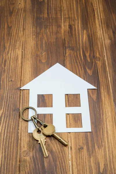 Huis met toets op houten achtergrond, nieuwe huis — Stockfoto