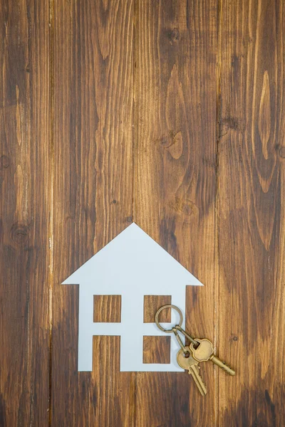Dům s klíčem na dřevěné pozadí, nový dům — Stock fotografie