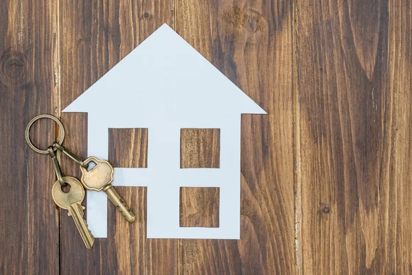 House ile ahşap arka plan, yeni bir ev üzerinde anahtar — Stok fotoğraf