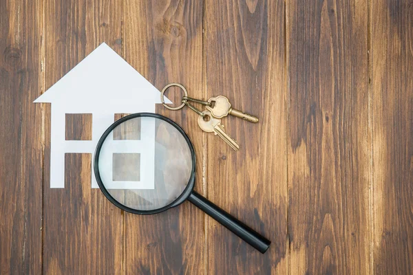 Papper house och nyckel med förstoringsglas, hus jakt — Stockfoto