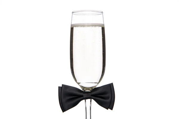 Glas Champagner mit schwarzer Fliege — Stockfoto
