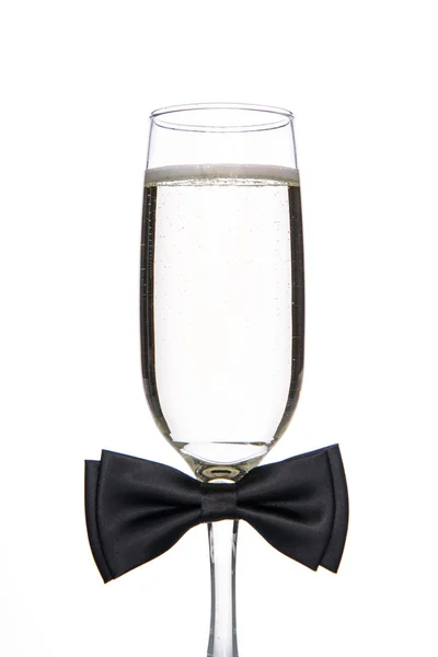 Glas Champagner mit schwarzer Fliege — Stockfoto
