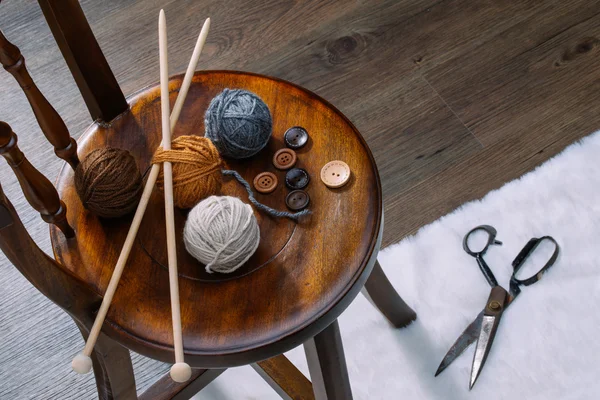 Bouton et boule de fil sur chaise en bois — Photo