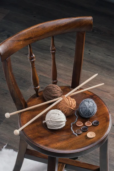 Bouton et boule de fil sur chaise en bois — Photo