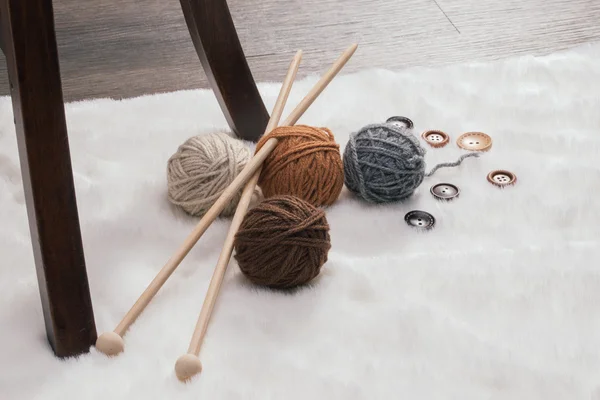 Bouton et boule de laine sur tapis — Photo