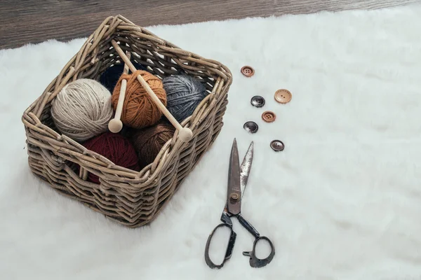 Ciseaux et boule de fil à l'intérieur du vieux panier sur le tapis — Photo