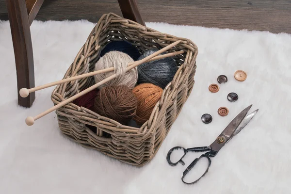 Ciseaux et boule de fil à l'intérieur du vieux panier sur le tapis — Photo