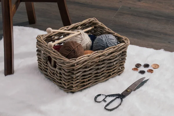 Ciseaux et boule de fil à l'intérieur du vieux panier sur le tapis — Photo