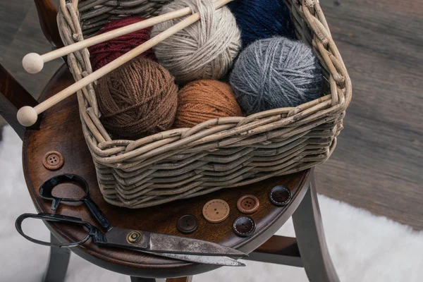 Ciseaux et fil à l'intérieur vieux panier sur chaise en bois — Photo