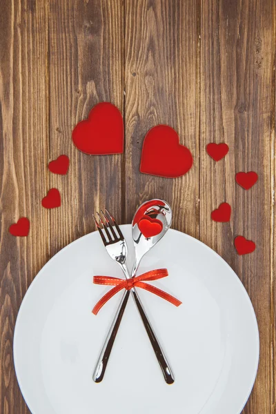 Celebra el día de San Valentín, forma de corazón y vajilla en un plato — Foto de Stock