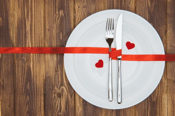 Celebra el día de San Valentín, forma de corazón y vajilla en un plato —  Fotos de Stock