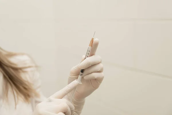 Doctor's hand with syringe on white background, vaccine theme, covid-19